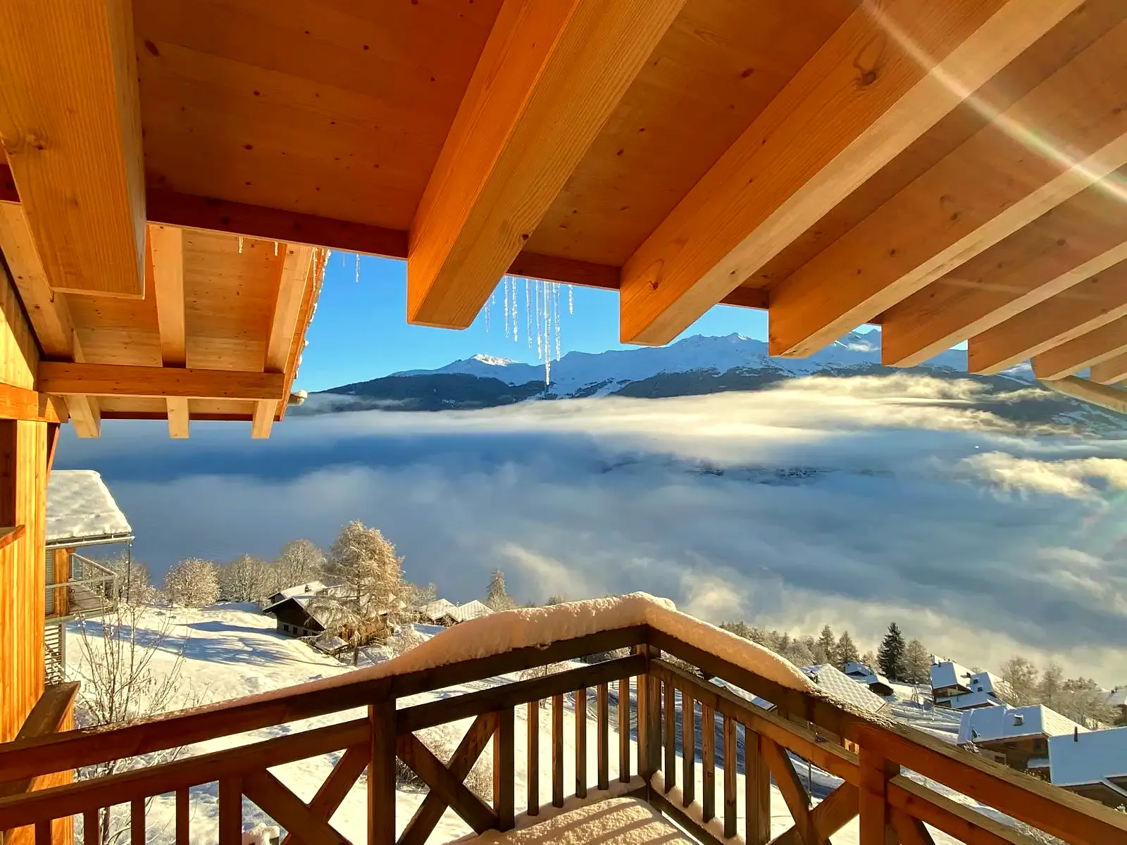 The chalet eaves in the sun above the clouds